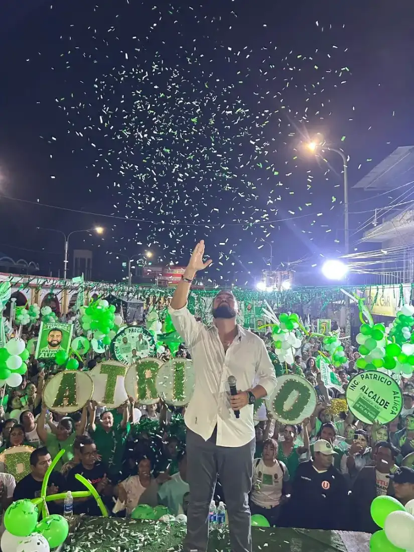 Patricio Aliaga en el escenario bajo confeti verde